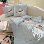 Puppy pillow blanket 2-in-1 set - baby blue polka dot cushions with embroidered white Westie dog wearing a red scarf and apple, one folded into a carry-handle bag shape, showing both S and L sizes on a cream sofa