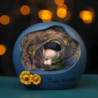 Van Gogh art night light glowing against warm bokeh lights - matte blue resin sphere with Starry Night swirl relief inside, chibi Van Gogh with dark curly hair and green coat sitting cross-legged, two yellow sunflowers and Enjoy the arts lettering on the base