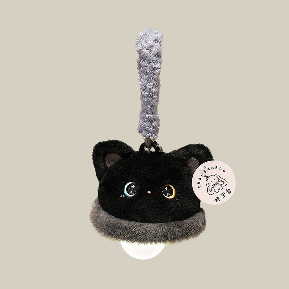 Black cat plush night light charm on a beige background - midnight black fluffy cat topper with moon and star embroidered eyes, silver ruff, warm white LED bulb glowing underneath, and a fluffy grey-lilac hang loop