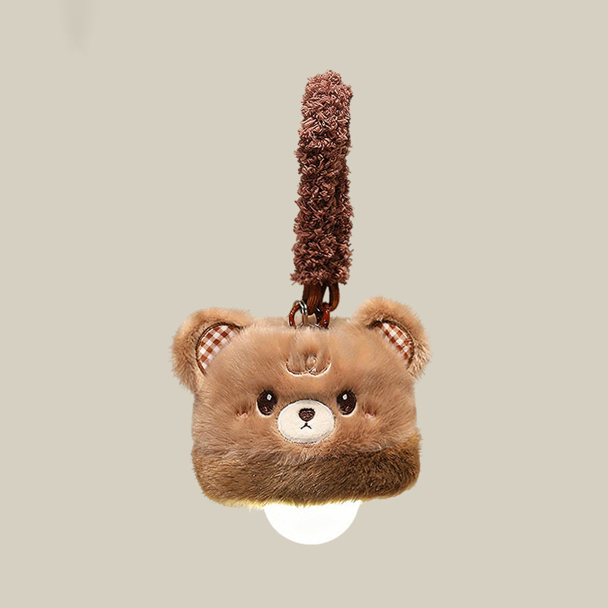 Bear plush night light charm on a beige background - toffee brown fluffy bear topper with gingham inner ears and embroidered smile, warm white LED bulb glowing underneath, and a fluffy brown hang loop