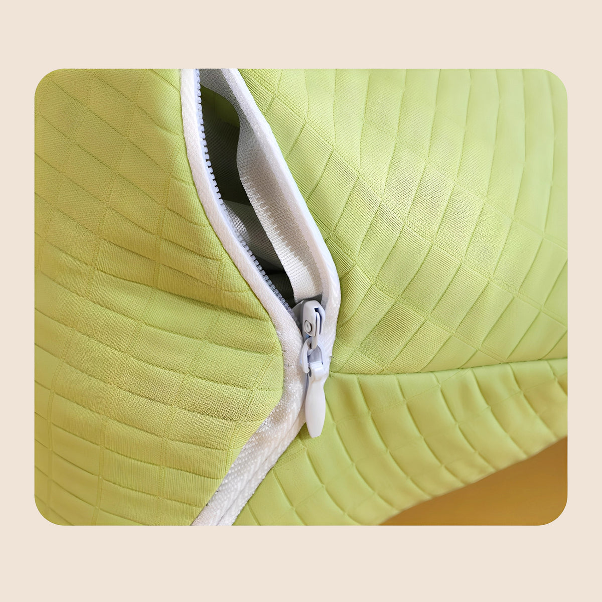Close-up of the zipper on the green triangle neck pillow - white zipper with fabric pull tab on the lime green quilted cover, showing the removable washable pillowcase seam