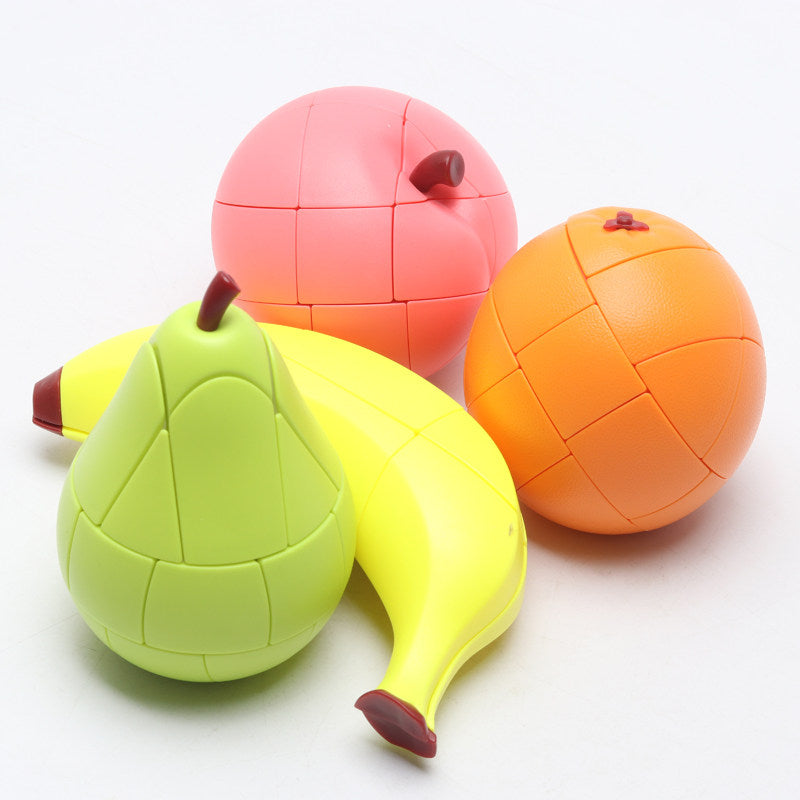 Four fruit shape cube puzzles grouped together on a white background - lime green pear, yellow banana, pink peach and orange, all 3x3 twisty cubes with stickerless moulded panels and stems