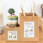 Treehouse perpetual calendar on its kraft gift box beside a matching kraft paper gift bag - both printed with For Your Special Moments and illustrated cottage, tree and flowers, ready to give