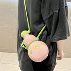 Person in a black tee wearing the Sweet Pink gourd water bottle crossbody on its green strap - bottle resting at hip level showing the FULL LOVE heart and sprout prints on the glossy pink body
