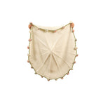 Cream hand-knit throw blanket with hand-stitched blush-pink and sage-green rose trim around the border, held open to show the circular knit pattern.